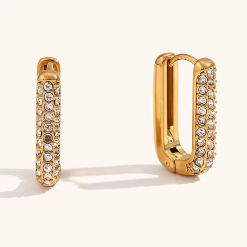 Gold hoop earrings with embedded crystals on a white background