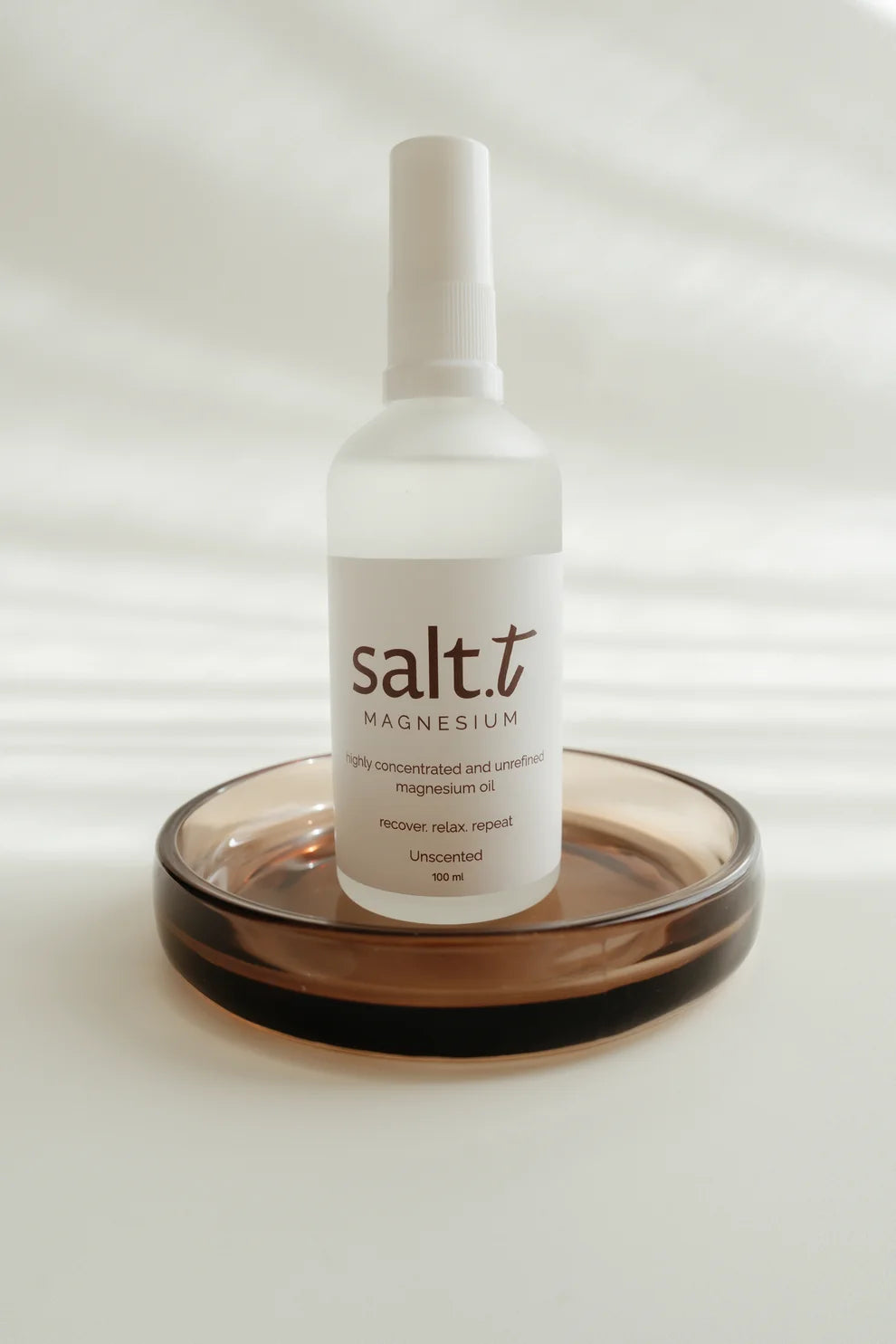 Bottle of salt.t magnesium oil on a white background